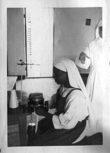 116149 Postulant bij de vervaardiging van een koord onder toeziend oog van een Witte Zuster