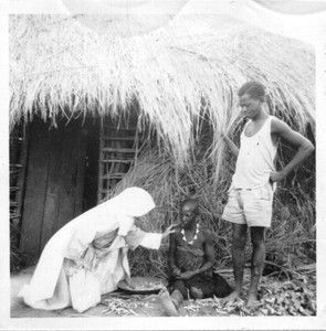 116174 Zuster Coletta bij een vrouw voor haar hut in het binnenland van Tanzania