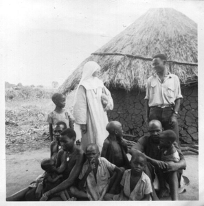 116175 Zuster Colleta te midden van inwoners van een dorp in het binnenland van Tanzania