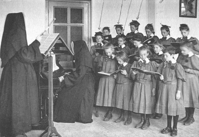 152262 Meisjes krijgen zangles van zuster Marghareta in de St. Antoniusschool te Bergen