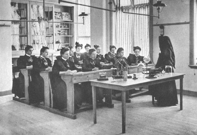 152263 Jongedames krijgen les van zuster Ignatia in het natuurkundelokaal van de St. Josephschool te Bergen