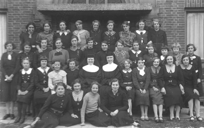 152268 Groepsfoto van de naaischool-leerlingen met zuster Placida (l) en moeder Engelberta te Warmerhuizen