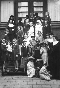 152283 Groepsfoto met verklede kinderen en enkele zusters tijdens het feest van de Onnozele Kinderen te Bergen