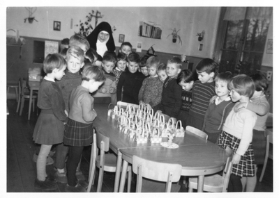 122151 Zuster Polycarpa bij het uitdelen van de paassurprises aan de kinderen van haar kleuterschool te Lutte (Losser)
