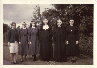 122193 Zusters gekleed in opeenvolgende habijten van door de decennia heen, in de moederhuistuin te Amersfoort