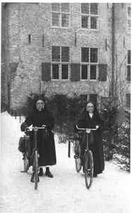 122206 De wijkzusters Lioba en Theodata met fiets aan de hand in de wintersneeuw te Amersfoort