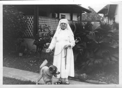 122224 Zuster Odulpha wandelend met hond bij haar klooster te Medan (Noord-Sumatra), Indonesië