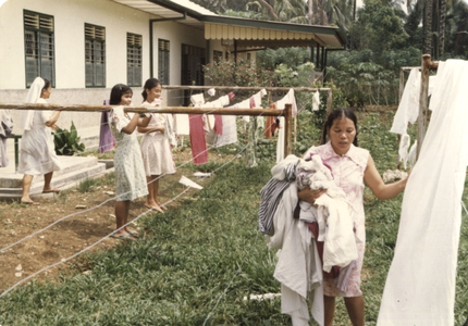 122260 Blinde meisjes leren het ophangen en afhalen van wasgoed in het internaat te Medan (Noord-Sumatra), Indonesië