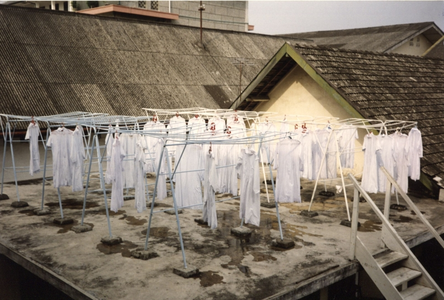 122276 Habijten hangen te drogen aan de waslijnen op het dak van het moederhuis aan de Jalan Hayam Wuruk te Medan, Indonesië