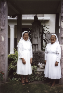 122299 Zusters Monica en Gabriël in de kloostertuin bij het beeld van de Heilige Jozef te Medan (Noord-Sumatra), Indonesië