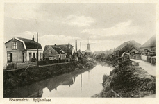 PB8910 De molen Nooitgedacht en het stoomgemaal langs de Vierambachtenboezem. Op de kade liggen bossen griendhout, ca. 1910
