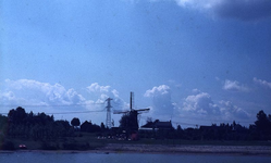 DIA00038 De molen van Abbenbroek aan de horizon, evenals een hoogspanningsmast; ca. 1985