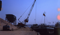 DIA69429 De zand en grindhandel bij de haven langs het Spui; ca. 1982