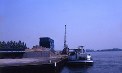 DIA69466 De zand en grindhandel bij de haven langs het Spui; ca. 1982