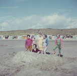 DIA_GF_1047 Kinderen op het strand hebben een zandkasteel gebouwd en met schelpen de tekst Donald Duck; 31 augustus 1962