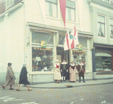 DIA_GF_1085 De familie W. van der Linden voor de winkel in de Voorstraat tijdens de 1 april viering; 1 april 1962