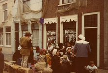 BR_1APRIL_1985_008 Briellenaren zijn verkleed tijdens het 1 april feest, op de ramen leuzen van kalknacht; 1 april 1985