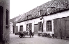 BR_BOTERSTRAAT_024 Kijkje in de Boterstraat, waar Gert van Gent een bakfiets voortduwt; ca. 1950