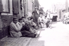 BR_ROZEMARIJNSTRAAT_066 Kijkje in de Rozemarijnstraat waar arbeiders zitten te schaften; ca. 1950