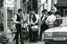 BR_VOORSTRAAT_552 Tijdens de Kolder Koopavond loopt een fanfare door de Voorstraat langs Snoepie; 9 augustus 1984