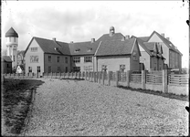 GN2051 De Hogere Burgerschool (HBS) met daarnaast de watertoren; ca. 1925