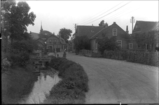 GN2452 Dorpsgezicht, links de kruidenierswinkel van A. Beijn. Links het café van Monster; ca. 1925