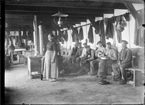 GN2763 Arbeiders in een loods, een vrouw bij een fornuis; ca. 1910