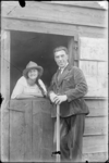 GN2982 Een man en een vrouw bij een half openstaande deur; ca. 1920