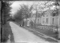 GN5131 Kijkje op de Zandweg waar een groep personen met een geit staan; ca. 1920