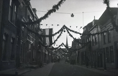 B1022 Tijdens een feest in Brielle zijn de straten met guirlandes en vlaggen versierd; 30 april 1947