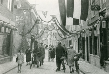 F1133 Versierde straat, op de achtergrond de Doelen; ca. 1913