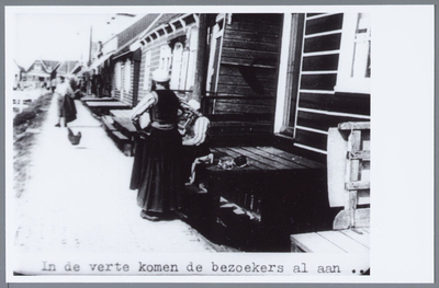 WAT001001942 Havenbuurt in Marken. Vrouwen in Marker klederdracht, voor de opgang van een woning op palen.