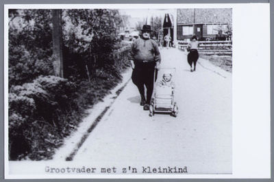 WAT001001992 Grootvader met z'n kleinkind. Man met kinderwagen, lopend op straat in Marken.