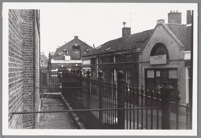 WAT001004561 Diaconie huisjes achter de lutherse kerk. Met op de achtergrond wjnkooperij H.Lau distilleerderij, sinds 1877.
