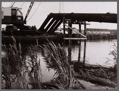 WAT001008074 Op de voorgrond zie je een aantal buizen waar ze zand door spoten voor de aanleg van de N244. Op de ...