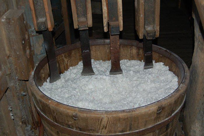 WAT120003667 In de lompenkamer van een papiermolen staat een langzaam ronddraaiende houten kuip waarin vier stampers ...