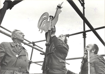foto-8116 Mevrouw T. Koster - Kay plaatst de opnieuw vergulde haan op de toren van de kerk, 1976, 22 december