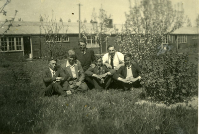119 - Groepsfoto van zes mannen voor een barak