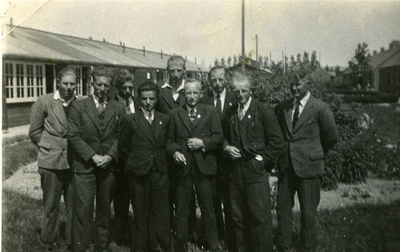 127 - Groepsfoto van negen mannen in een kamp