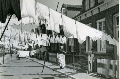 193 - Wapperend wasgoed en een lopende vrouw in Urker klederdracht