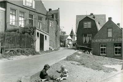 203 - Aflopend straatje met pand schildersbedrijf van K.J. Coenen en twee in het zand spelende kinderen
