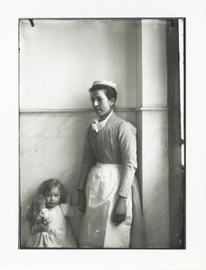 1539 - Dienstbode met dochtertje Julie in de hal van huize Bas Backer aan de Van Kinsbergenstraat.