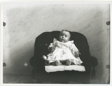 1557 - De kleine Julie Bas Backer pontificaal voor de foto op de stoel.