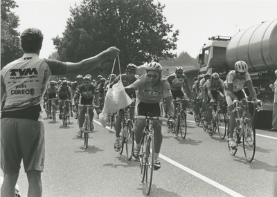 1712 - Profronde van Nederland doet Veluwe aan. Jeroen Blijlevens pakt de etenszak aan van de verzorger.