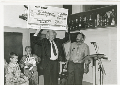 1840 - SV 't Harde verrast met tienduizend gulden. Voorzitter Bruss met de cheque en de voorzitter van de ...