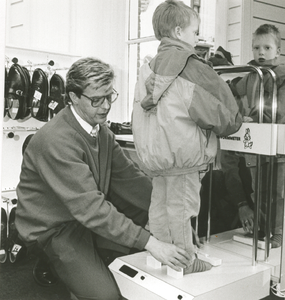 1897 - Henk Veenbergen van Veenbergen Schoenmode past een kleuter schoenen aan.