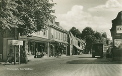 Nr.: 11904 - Nunspeet, Dorpstraat zicht op de winkelstraat met links een ANWB-paal met borden richting Amersfoort en ...