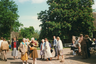 N 8048 - excursie Nuwenspete; vrouw in rode trui met parelketting: Evie Hardlooper; vrouw, die in haar tas kijkt: ...