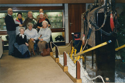 N 8057 - groep mensen in ruimte met museale opstellingen; bovenste rij, vlnr: Aad de Leeuw; bezoekster; G. Kunz; ...