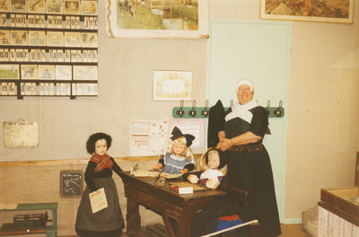 N 8120 - vrouw, in streekdracht, bij deel opstelling oudheidkamer; Gerrie Rekers bij 'het schooltje'